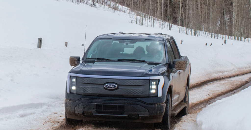 Ford F-150 Lightning Driving Through a Snowy Landscape Front 3/4 View